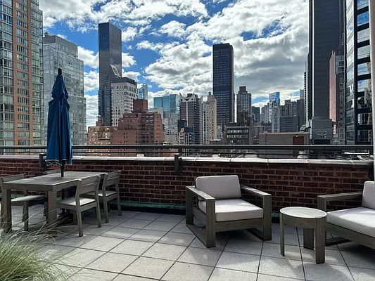 Rooftop with outdoor seating and city skyline view.