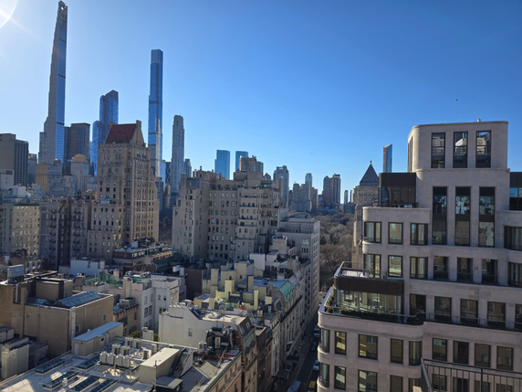 Panoramic view of a city skyline with tall buildings under a clear blue sky.