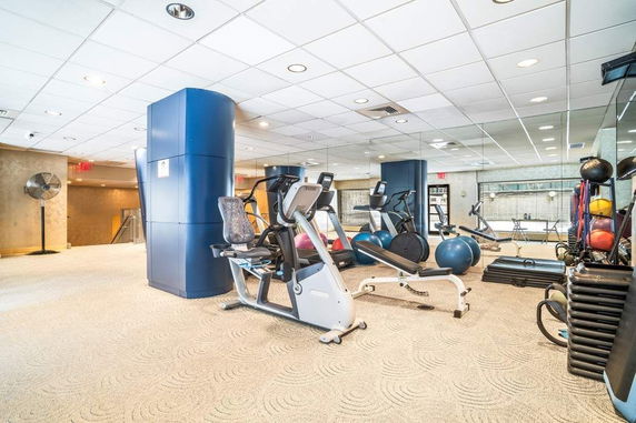 Interior view of a gym with exercise equipment and mirrors.
