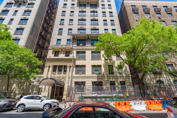 Front view of a multi-story building with decorative elements and a covered entrance.