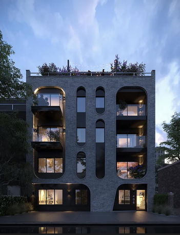 Front view of a modern multi-story building with a rooftop garden.