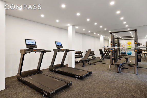 Indoor gym area with treadmills, weightlifting bench, and exercise equipment.