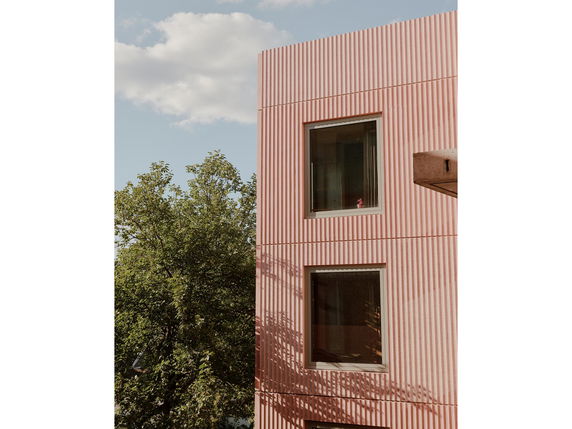 View of a modern building with vertical striped facade and large windows.
