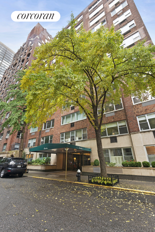 Front view of a multi-story brick building with entrance canopy.