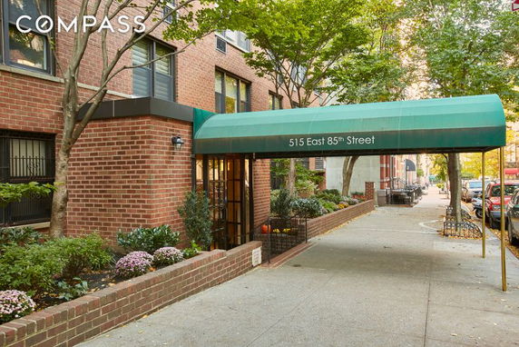 Front view of a multi-story brick building with a green awning entrance.