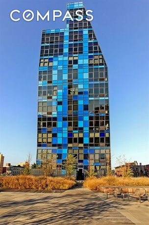 Front view of a tall building with a distinctive blue and glass facade.