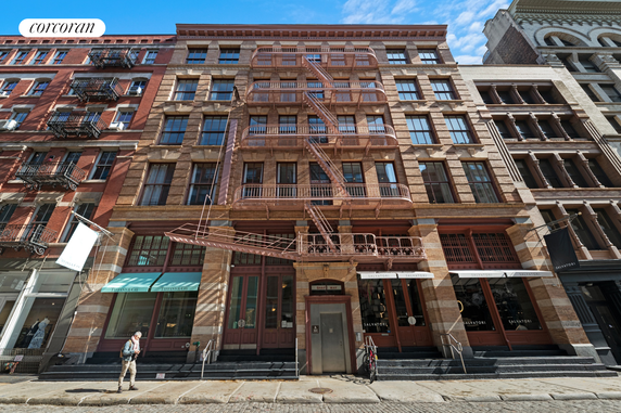 Front view of a multi-story building with fire escape stairs.