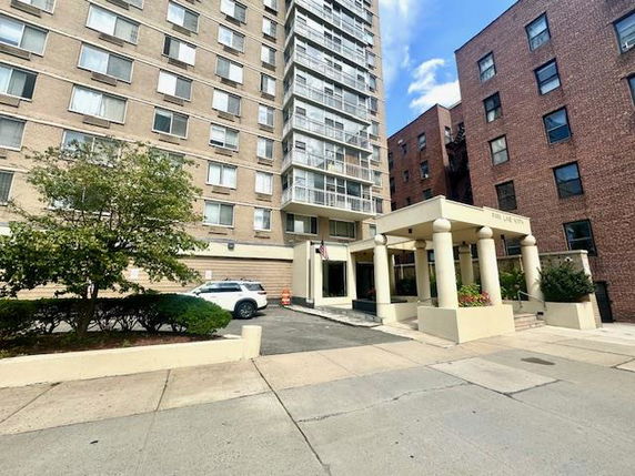 Front view of a multi-story apartment building with an entrance canopy.