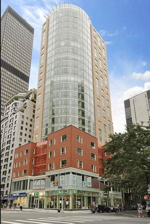Front view of a tall multi-story building with glass and brick facade.