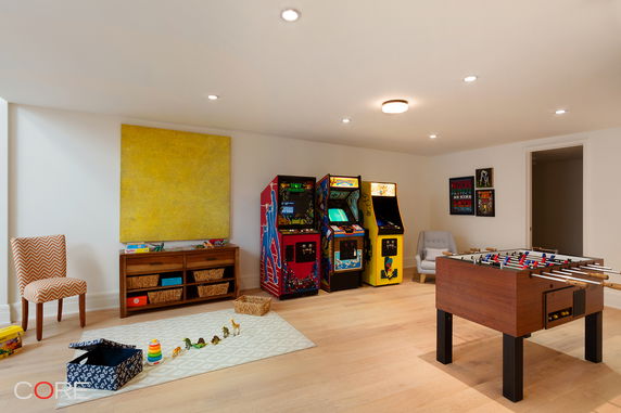Room with arcade machines, foosball table, and toys.