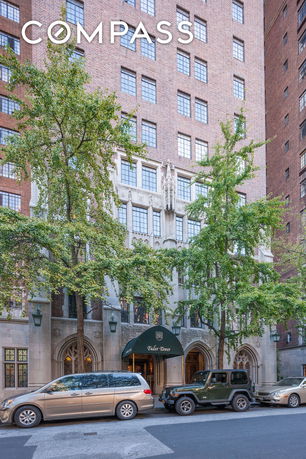 Front view of a multi-story brick building with decorative stonework and arched entrance.