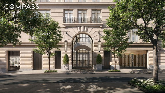 Front view of a multi-story building with an arched entrance and decorative elements.