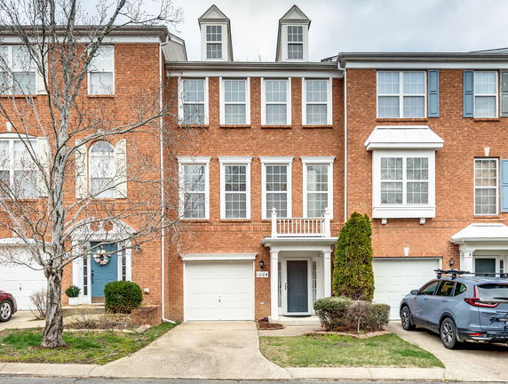 Front view of a multi-story brick townhouse with integrated garage.