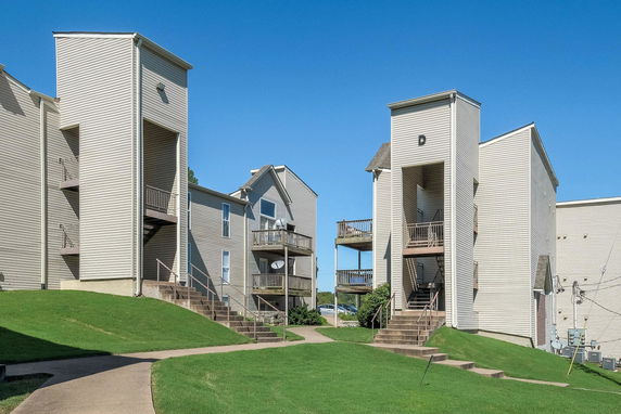 Front view of a multi-story apartment building with external staircases.