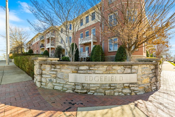Front view of a multi-story brick and cream-colored apartment building named Edgefield.