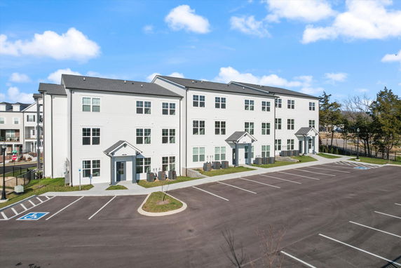 Front view of a three-story apartment building with multiple entrances.
