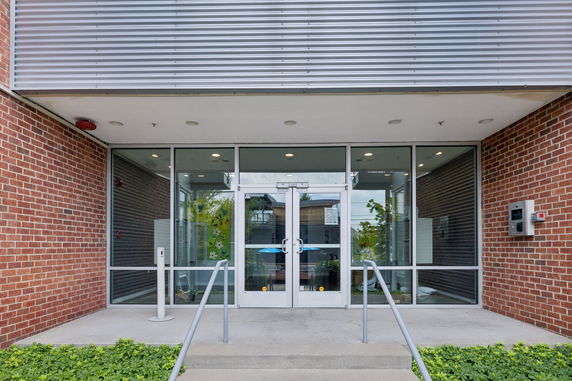Front view of a building entrance with glass doors and brick exterior.