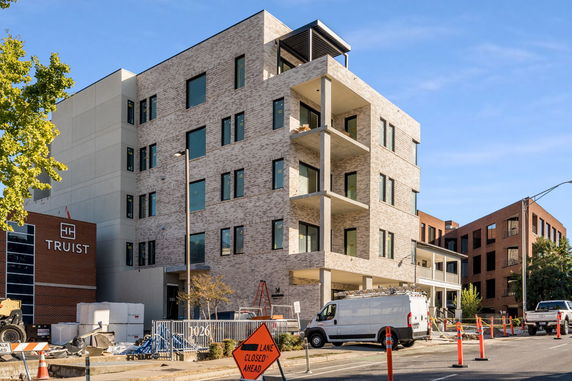 Front view of a multi-story brick building with large balcony areas.