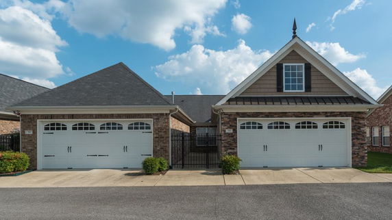 Front view of a house with two garages and brick exterior.