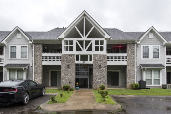Front view of a two-story residential building with balconies and brick facade.