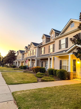 Row of multi-story townhouses with porches and dormer windows.