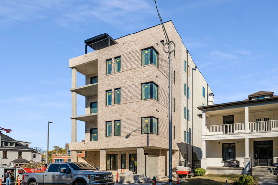 Front view of a multi-story building with a modern design and balconies.