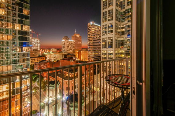 Night view of a city skyline from a balcony.