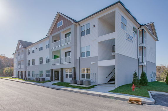 Front view of a three-story apartment building with balconies.