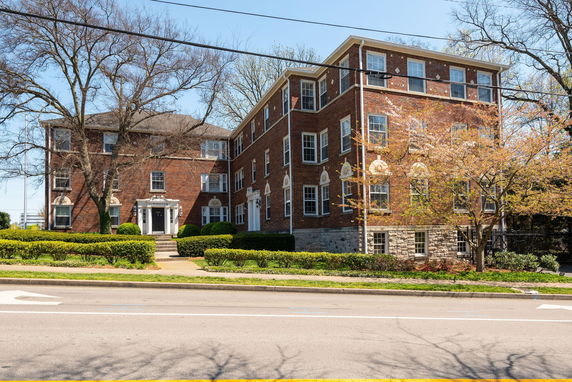 Front view of a three-story brick building with multiple windows and an entrance.