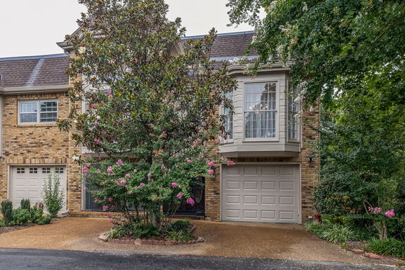 Front view of a two-story brick house with an attached garage.