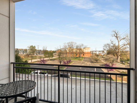 Panoramic view of a parking area and surrounding buildings from a balcony.