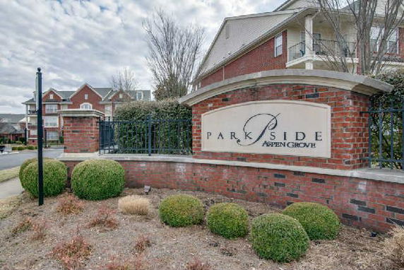 Front view of residential buildings with a brick sign reading 'Park Side Aspen Grove'.