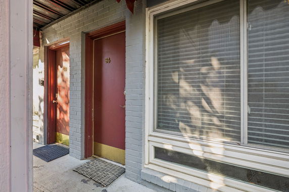 Front view of a building with red doors and large windows.