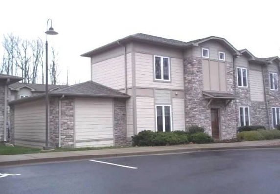 Front view of a two-story townhouse with stone and siding exterior.
