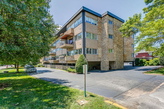 Front view of a multi-story brick apartment building with balconies.