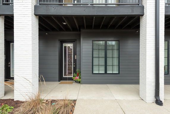 Front view of a house with a dark gray exterior and a modern entrance.