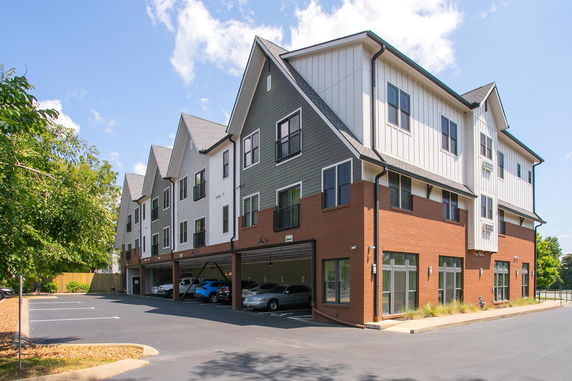 Front view of a multi-story building with a brick and siding exterior.