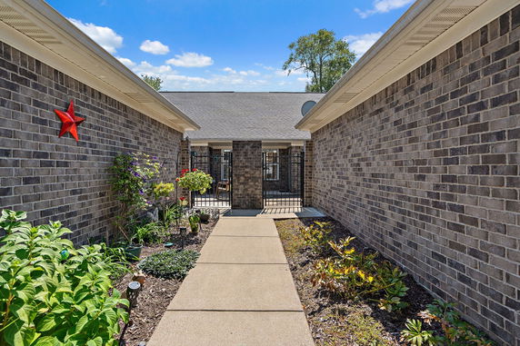Front view of a brick house with a pathway leading to the entrance.