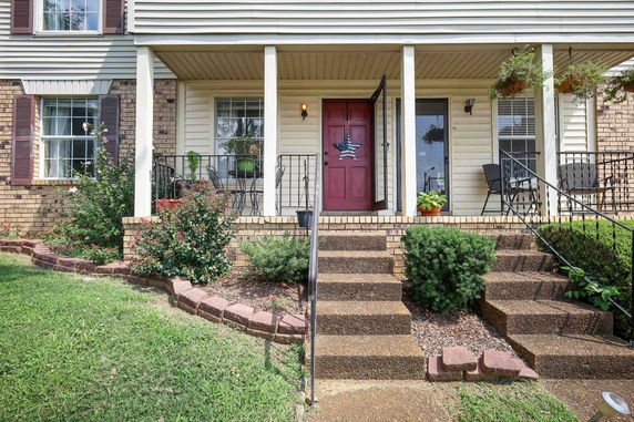 Front view of a house with a brick exterior and a red door.