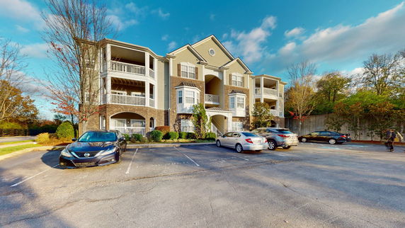Front view of a three-story apartment building with balconies.