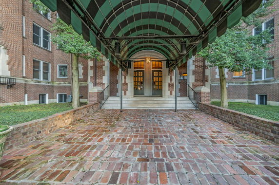 Front view of a brick building with an awning.