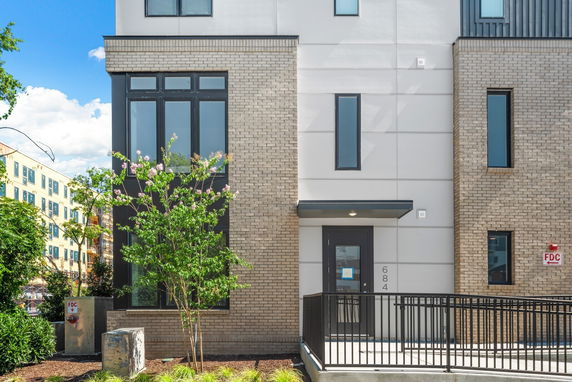 Front view of a modern multi-story building with brick and panel facade.