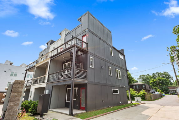 Front view of a modern multi-story building with balconies and large windows.