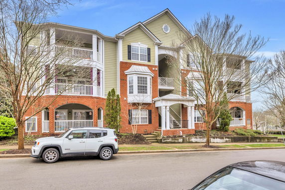 Front view of a multi-story residential building with brick and siding exterior.