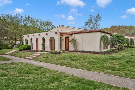 Front view of a single-story house with arches and a flat roof.
