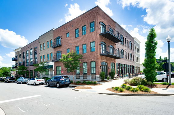 Front view of a multi-story brick building with balconies.