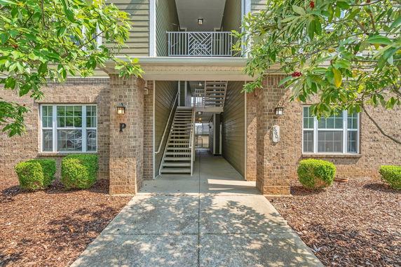 Front view of a multi-story residential building with a staircase entry.