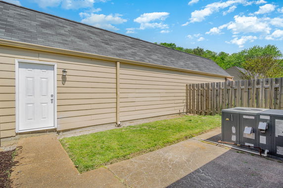 Side view of a building with a single door and a wooden fence.