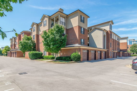 Front view of a multi-story apartment building with brick and stucco exterior.