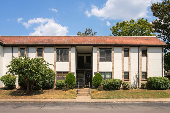 Front view of a two-story building with multiple windows and a central staircase.